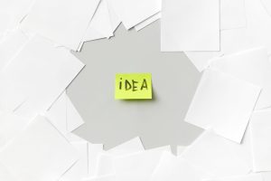 a word idea written on a yellow post stuck on a white surface