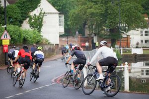 a group of cyclists riding down a road
