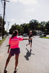 volunteer aiding marathon runner on sunny day