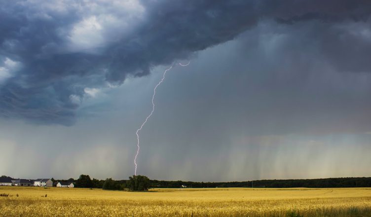 dramatic thunderstorm over farmland landscape
