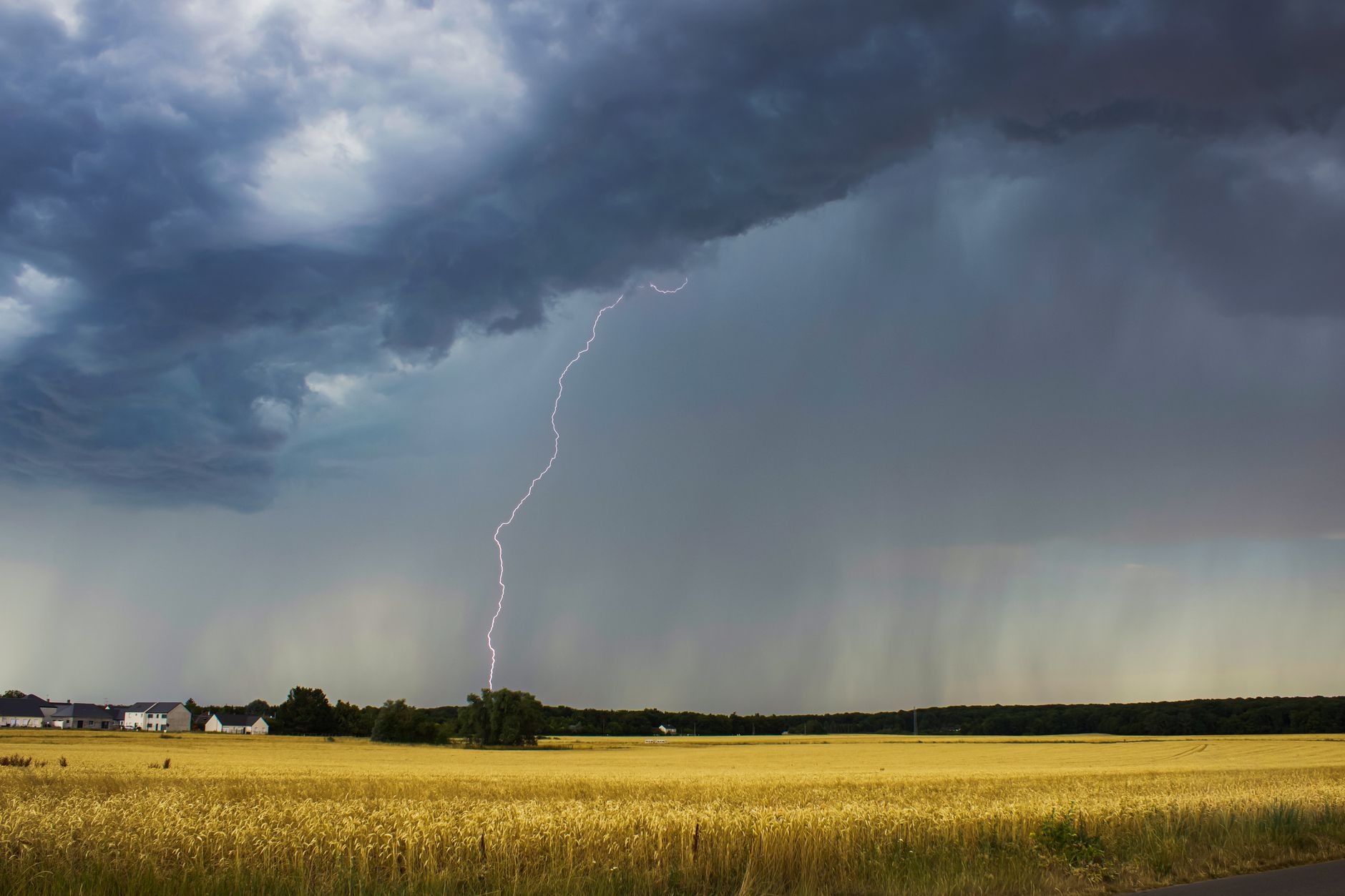 dramatic thunderstorm over farmland landscape