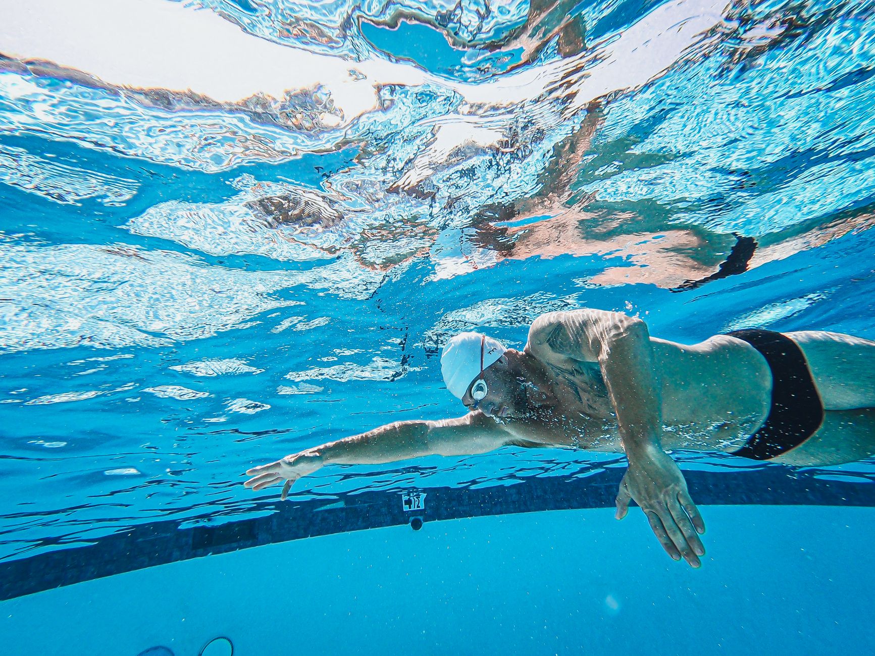 a man wearing swimming cap and googles swimming